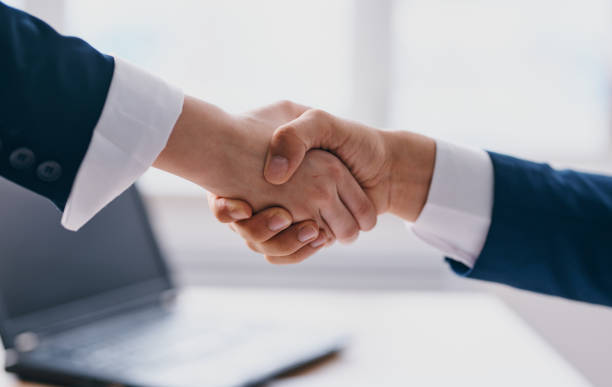 istock Business people shake hands on a light background office window laptop 2126882705