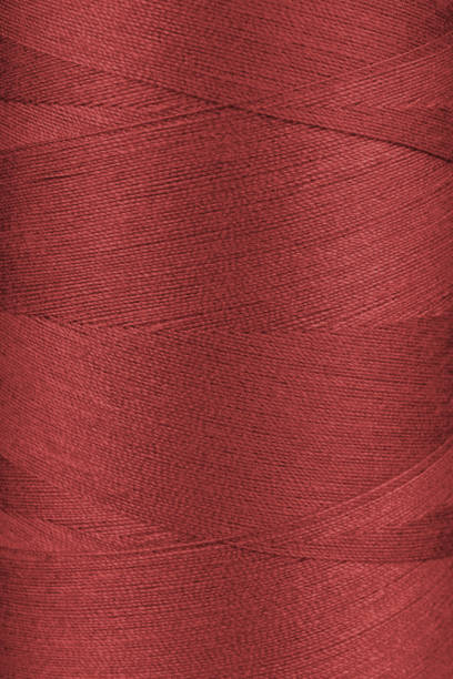 istock Texture of red color threads in spool close up, macro 2126930256