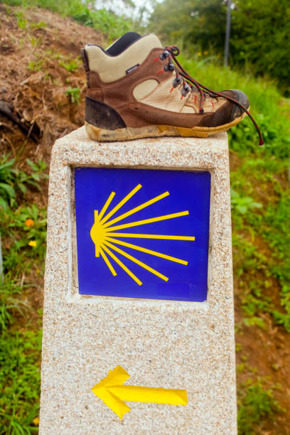 istock Pilgrims shell and old boot in the Camino de Santiago 2126932331