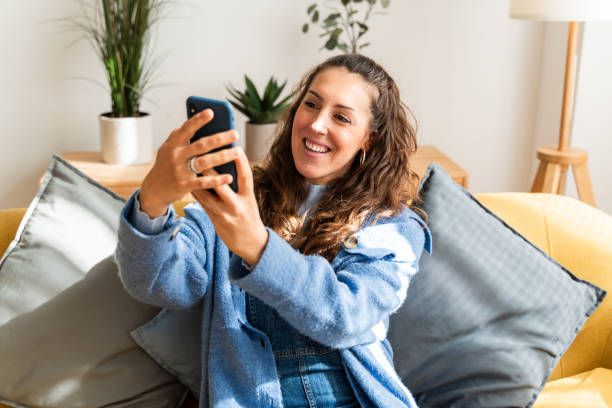 istock Happy woman taking selfie on couch 2126954331