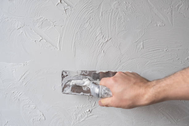istock Applying decorative putty. White abstract texture of surface covered with putty 2126973995