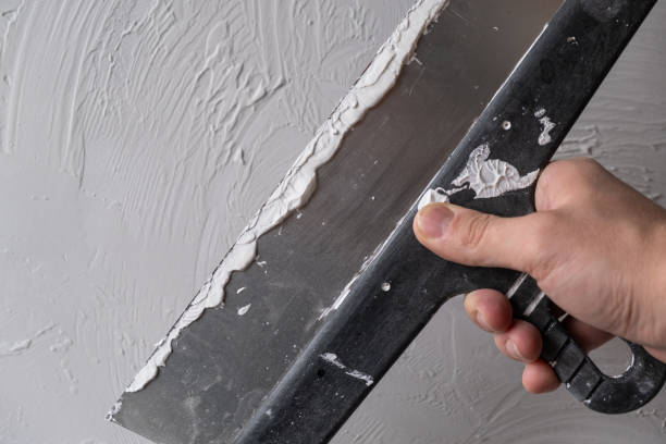 istock Applying decorative putty. White abstract texture of surface covered with putty 2126978123