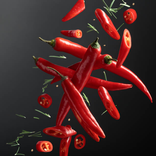 istock Red chili peppers and rosemary on a black background. 2127018019