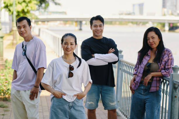 Smiling friends standing on river embankment