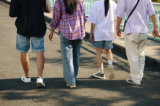 Crop image of young people walking on street