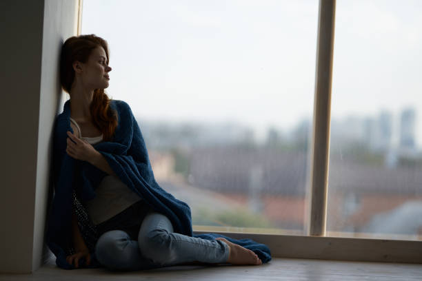 istock woman sits on the windowsill covered with a blanket attractive look rest 2127059005