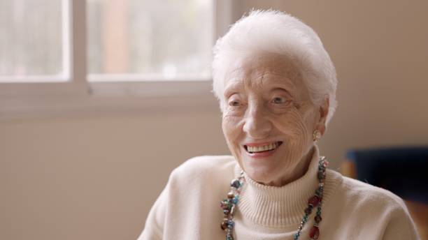 Black and white portrait of beautiful smiling senior woman, front view, background with copy space, horizontal composition