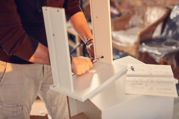 istock Man working and assembling furniture in a new apartment. 2127100517