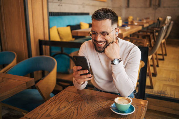 istock Modern man in casual clothes using smartphone in cafe 2127106884