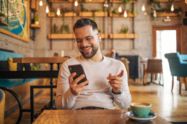 istock Happy man having video chat via smartphone in cafe 2127118404
