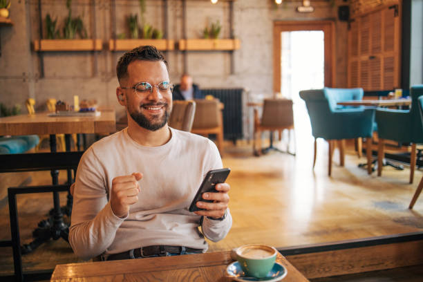 istock Happy man having video chat via smartphone in cafe 2127123937