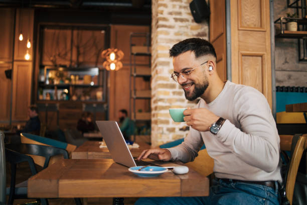 istock Young businessman using laptop and having video call at coffee shop 2127143883