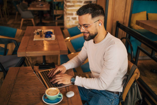istock Young businessman using laptop and having video call at coffee shop 2127144906
