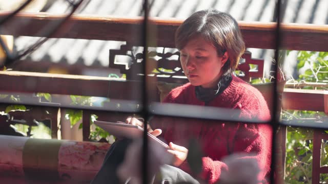 Woman Using Tablets in a classical Chinese Architectur