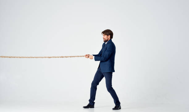 istock business man in a suit pulls a rope on a light background 2127174667