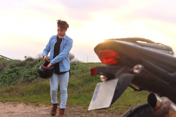 istock Curly haired Caucasian young man comes walking to his motorcycle 2127176238
