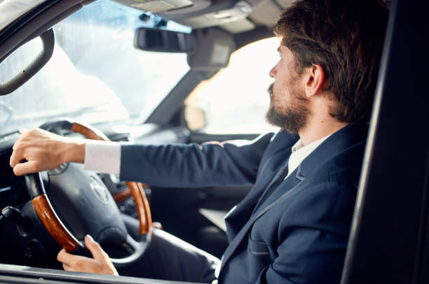 istock Cheerful business man in a suit driving a car trip passenger road 2127190835