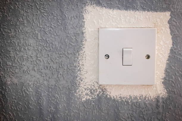 istock light switch on painted wallpaper wall texture closeup during home renovation 2127215104