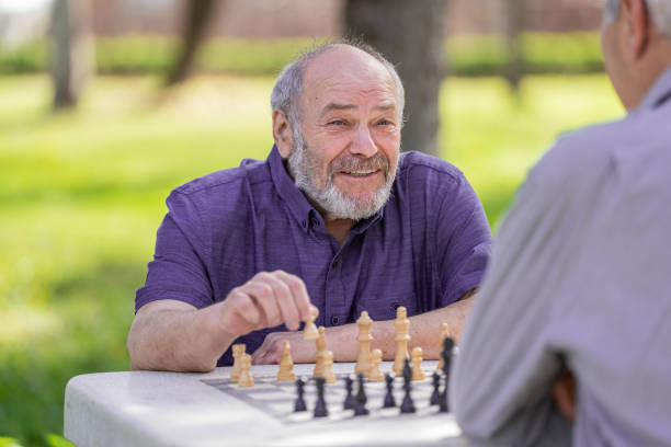 istock Chess, nature and retirement with senior friends playing a boardgame while bonding outdoor during spring. 2127352305