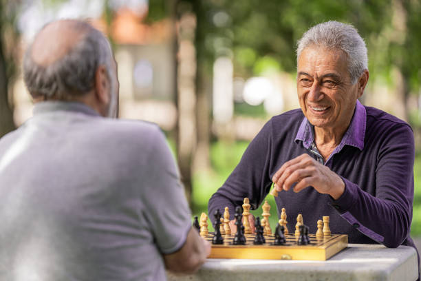 istock Chess, nature and retirement with senior friends playing a boardgame while bonding outdoor during spring. 2127352491