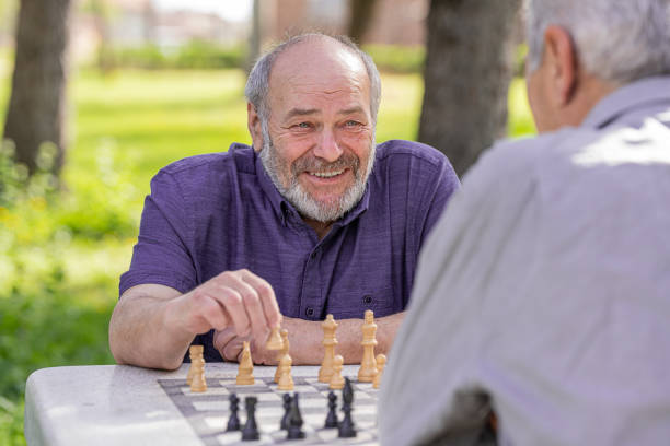 istock Chess, nature and retirement with senior friends playing a boardgame while bonding outdoor during spring. 2127352494