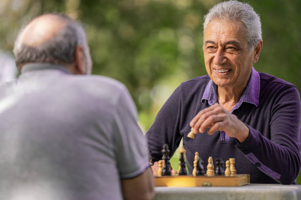 istock Chess, nature and retirement with senior friends playing a boardgame while bonding outdoor during spring. 2127352495
