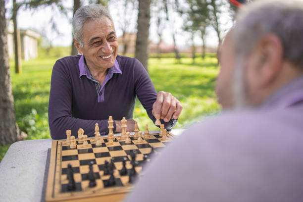 istock Chess, nature and retirement with senior friends playing a boardgame while bonding outdoor during spring. 2127352496