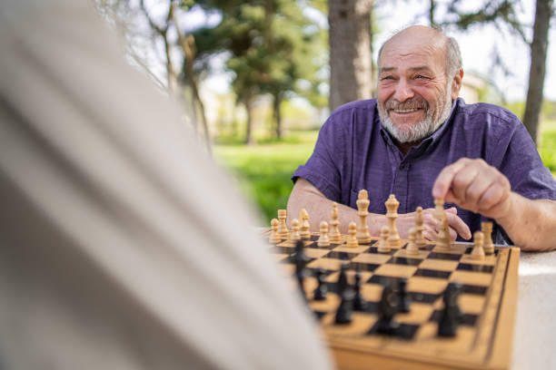istock Chess, nature and retirement with senior friends playing a boardgame while bonding outdoor during spring. 2127352498