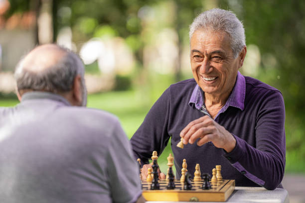 istock Chess, nature and retirement with senior friends playing a boardgame while bonding outdoor during spring. 2127352502