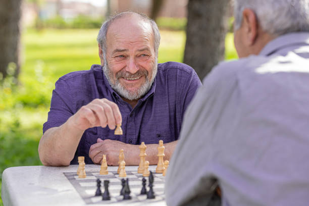 istock Chess, nature and retirement with senior friends playing a boardgame while bonding outdoor during spring. 2127352511