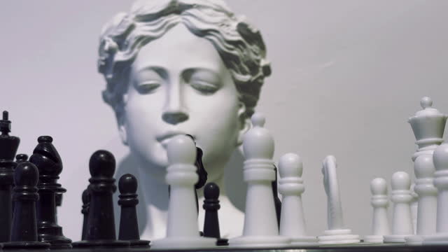 Strategy game Chess and ancient greek statue head