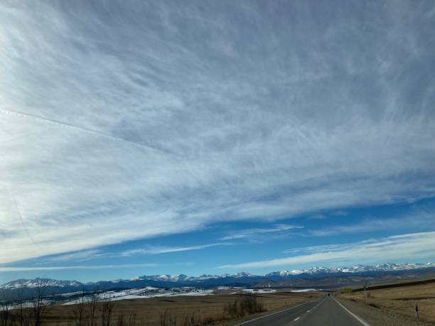 istock Panoramic mountain landscape snow road field sky sun clouds 2127399218