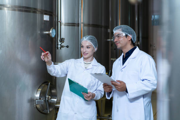 istock Mature female and male researchers and developers working in winery, Testing wine that has been fermented for a while. 2127467827