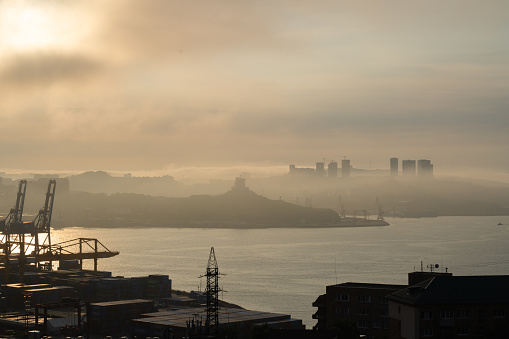 Vladivostok, Russia - July 28, 2023: Silhouettes of cranes in the seaport of Vladivostok, the largest year-round port on Russian Far East. It is at the beginning of the Trans-Siberia Railway