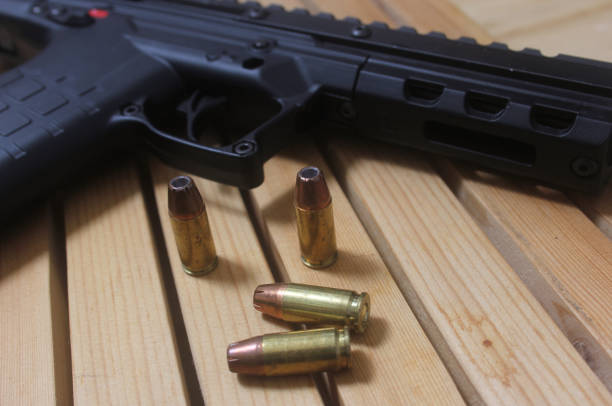 istock a gun laying on top of bullet shells on a table 2127469437