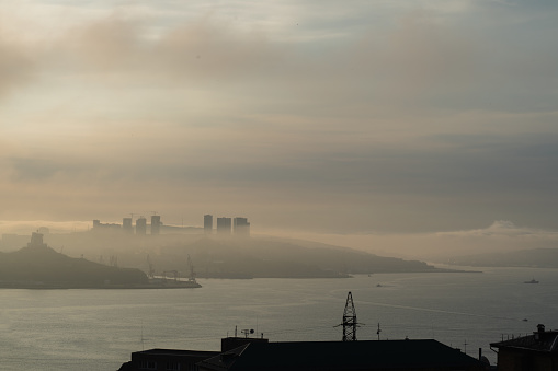 Foggy morning at the city on the seashore of Pacific ocean. Calm morning in Vladivostok, Russia on the July 28, 2023