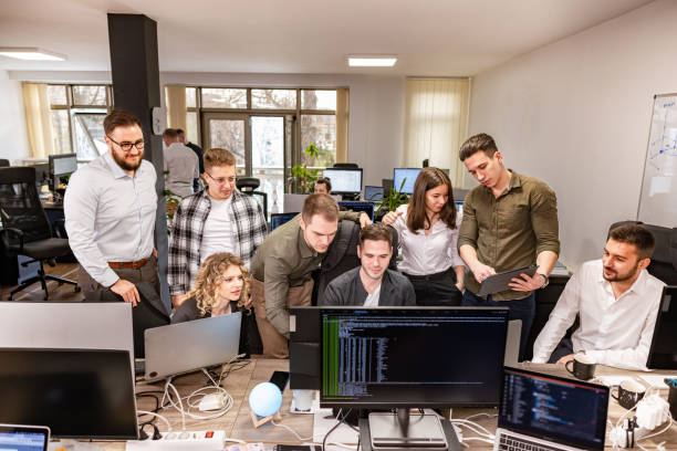 istock Group of Caucasian male and female computer programmers working on computer at the open space office 2127490460