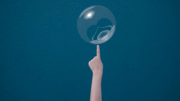 istock Risk management concept kid finger pointing or pricking to soap bubble floating on air. Risk, danger, fragility concept 2127491499