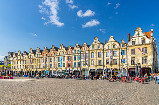 Arras, France, July 3, 2023: Flemish-Baroque-style townhouses buildings on La Petite market Place des Heros Heroes Square in city center, blue sky in summer day, Artois, Pas-de-Calais department