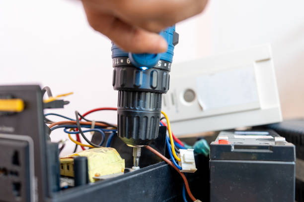 istock Close up Hand of man using a drill to remove the screws from the UPS battery backup for personal Computer to repairs. Electronic waste. 2127523741