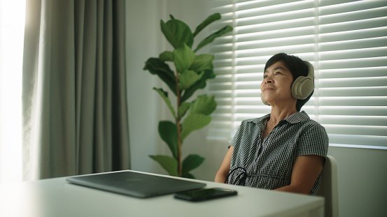 Asian mature woman taking a break while work from home.