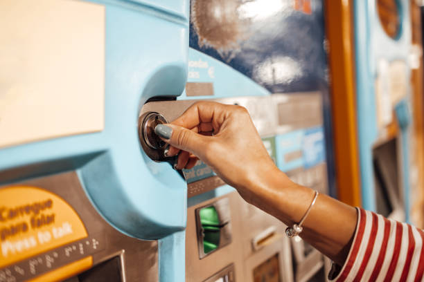 istock Young woman using ATM machine on a street. 2127572726