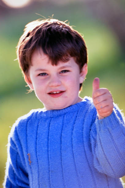young boy showing his thumb to say ok