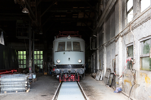 Weimar, Germany – May 30, 2015: A historical electric railcar stands on a track in the locomotive shed.