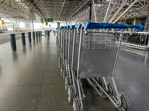 Luggage trolleys lined up at airport departure entrance