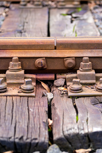 Detailed shot of a weathered railway track with rusted rails and aged wooden sleepers