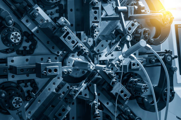 istock Close up the coil spring forming machine in light blue scene. 2127645113