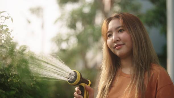 istock Asian woman watering the plants. 2127661928