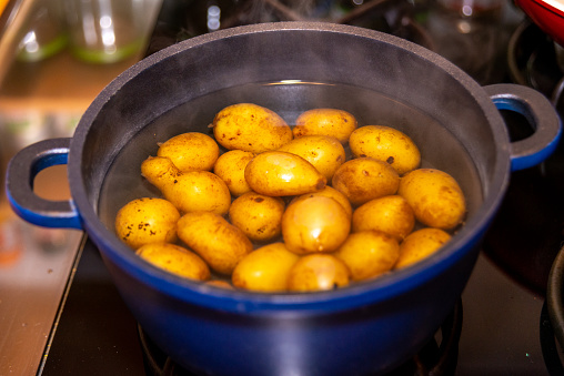 Yellow baby potatoes piled in a blue enameled pot, ready for cooking