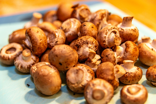 Pile of fresh cremini mushrooms, also known as baby bellas, with rich brown caps
